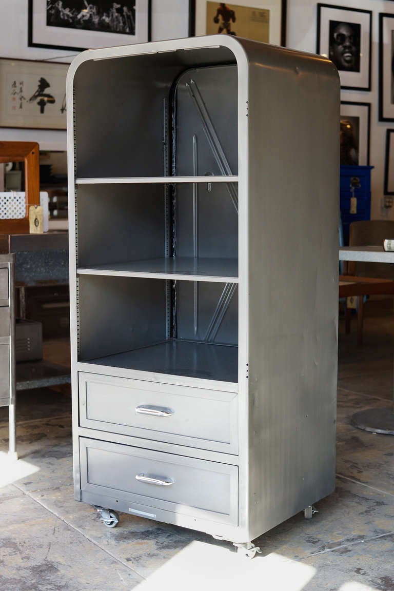 This antique 1950s steel refrigerator/ freezer unit is repurposed to function as a retro-style cabinet or storage case. Three spacious shelves and two custom-made drawers in a beautiful natural steel finish. 

Makes a stunning bookcase, wardrobe