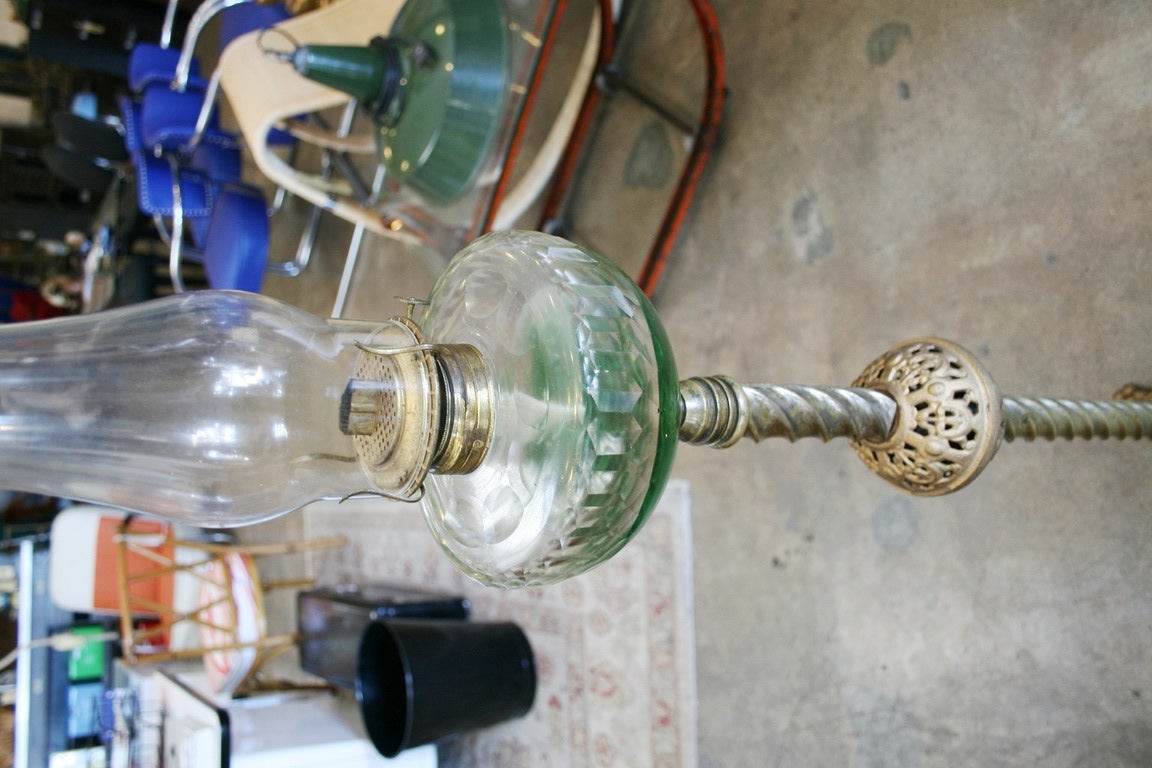 This oil burning floor lamp was created by Eagle and dates back to 1893 with very ornate brass parts and base. The base is finished off with four traditional claw feet. Lamp stands 58