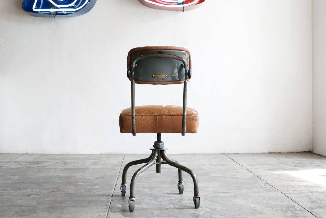 1940's vintage machine age SteelCase task chair newly reupholstered in brown nad white cowhide with pebbled vinyl trim. The steel frame and hardware are cleaned and clear-coated to accentuate their unique vintage color and patina.

Swivels,