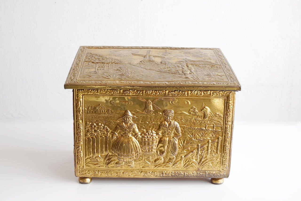Antique Victorian coal box, c. 1890. Beautifully hand-embossed brass depicts a detailed Dutch countryside scene.

Dimensions: 11