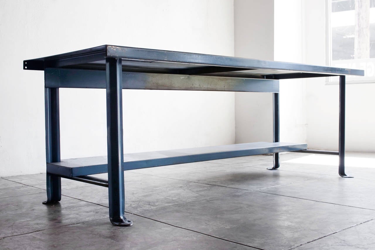 Heavy-duty Industrial work bench in a blue painted steel. Features unique machine age legs and single bottom shelf. Wonderful patina, circa 1950s.

Measures: 36