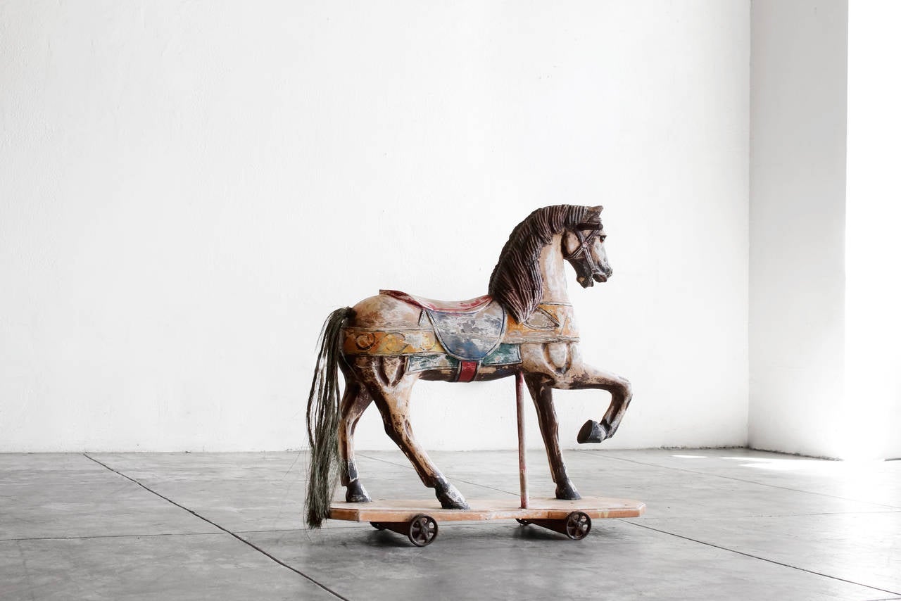 Lovely carousel style horse toy with hay-like tail. Hand-painted wood is full of charm. Rolls on steel wheels. 

Dimensions: 32.5