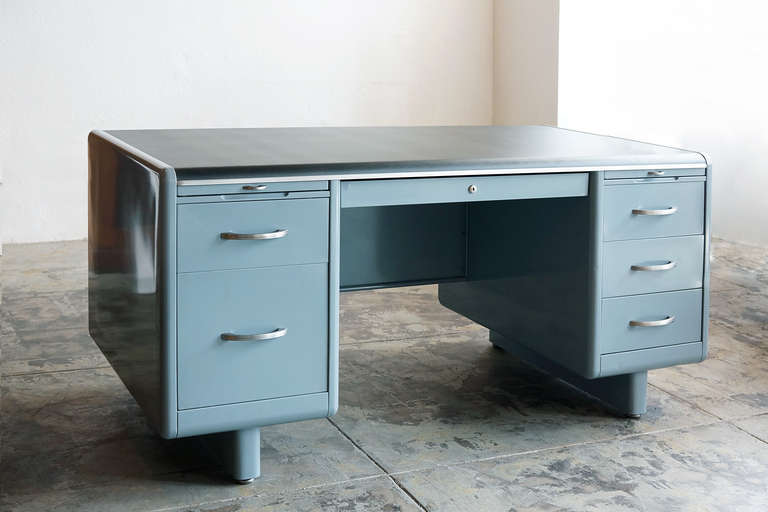 1930's double pedestal tanker desk by Steel Age. Refurbished in a smokey blue powder-coated finish and new linoleum top, this desk is a stunner. It features original deco-style hardware and seven drawers including a filing drawer and two pull-out
