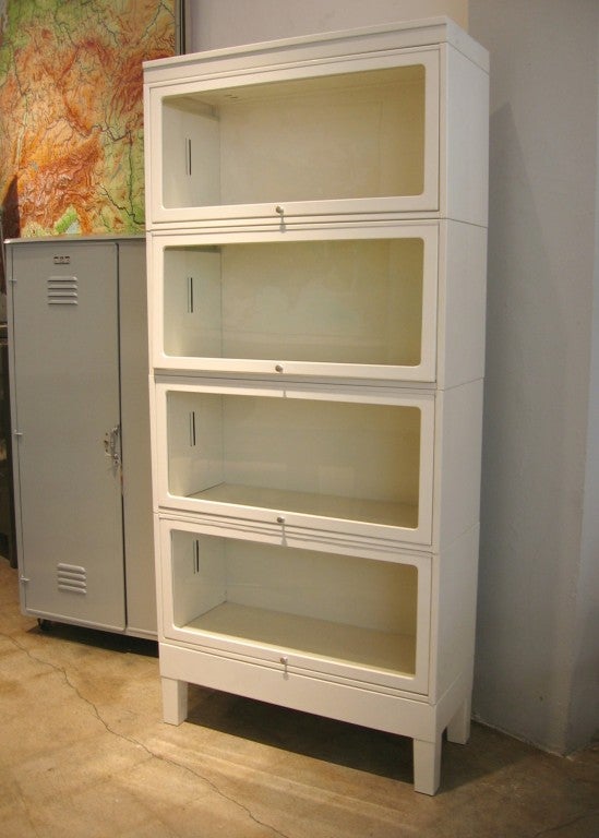 Sectional vintage steel lawyers bookcases with flip-top disappearing glass doors were new in the 1920's and still look contemporary today. They are modular and light weight but durable. REHAB restores them in our natural steel finish or any custom