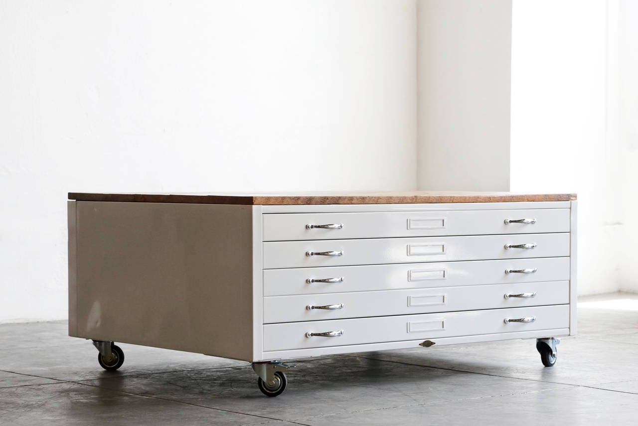 Vintage architect's flat file cabinet repurposed for use as a coffee table. Refinished in high gloss white with brushed aluminum hardware and reclaimed wood table top. The use of industrial and organic materials makes for an unforgettable statement
