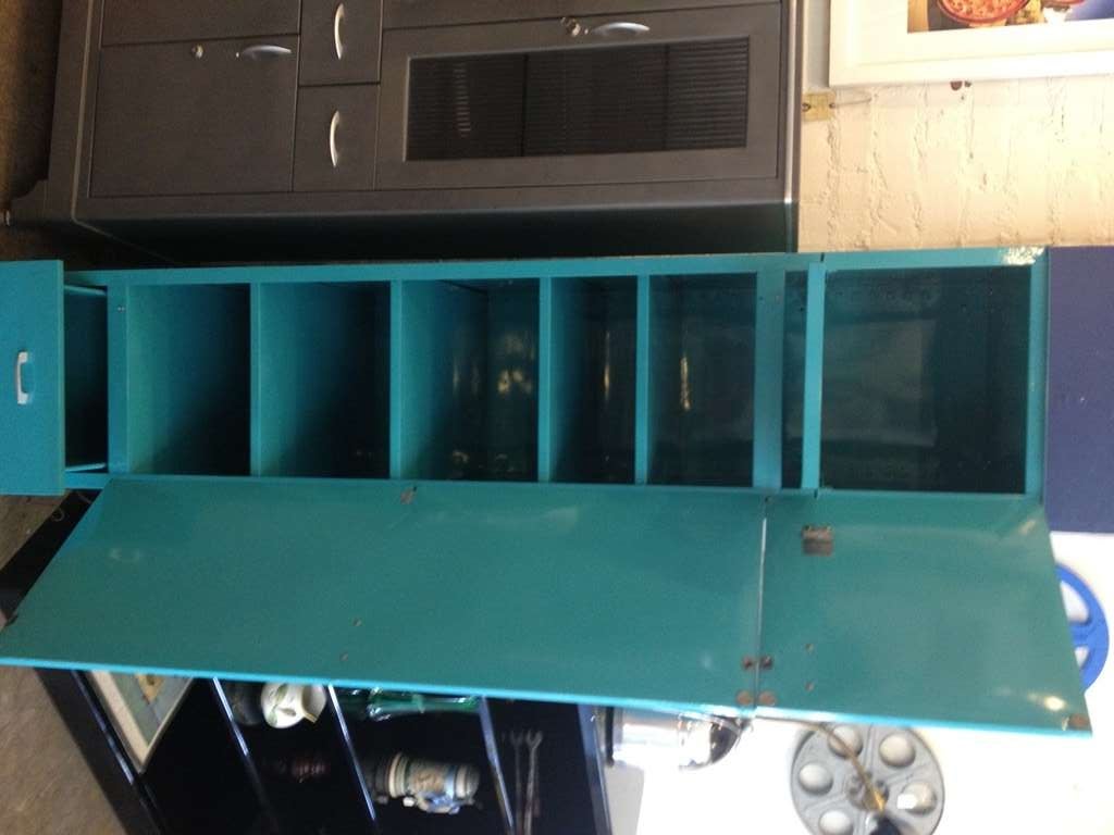 Vintage kitchen cabinet, refurbished with a teal green powder coat finish.  Features brushed hardware, a top slide-out panel, 4 adjustable shelves, and a bottom drawer for storage.