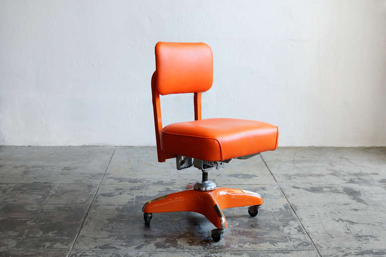 This classic 1950's steno chair is newly refinished in a orange on orange powder-coated frame and seat. Features original, iconic hardware- industrial adjustment knobs and chrome toe caps.

Adjusts, swivels, and rolls on casters. 

Please see