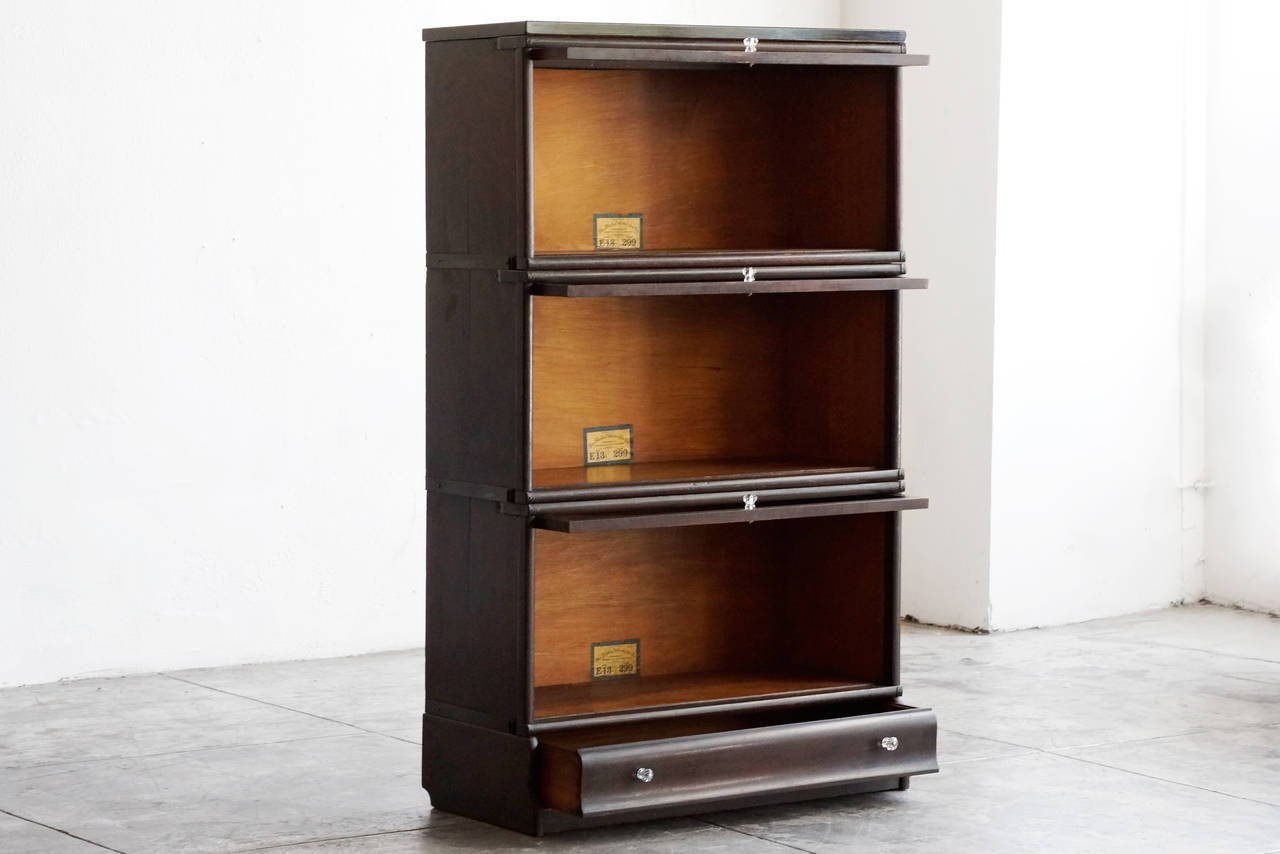 Stack of three antique bookcases by Globe Wernicke. Original glass doors, tiger oak frames and glass knobs. Features uncommon extra bottom drawer.

Dimensions: 14