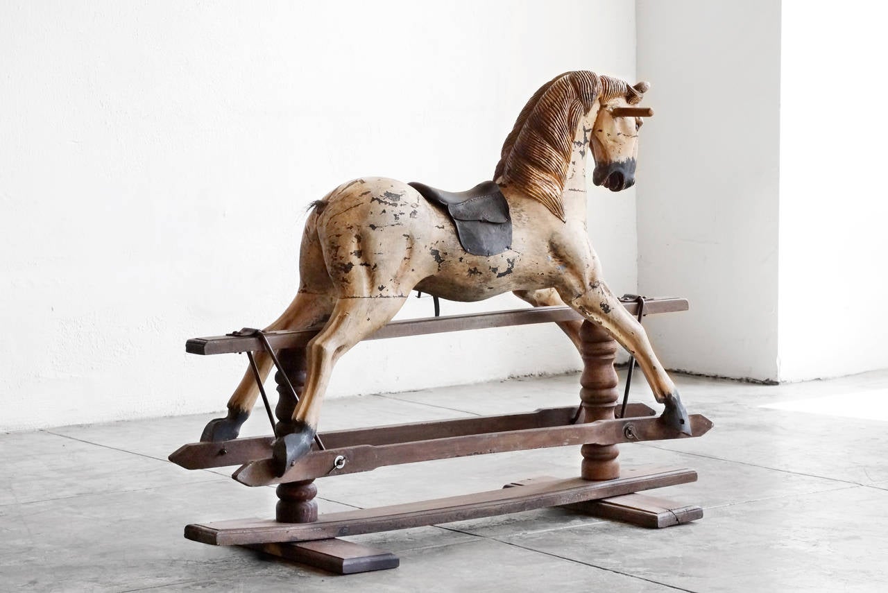 Handmade wooden rocking/ prancing horse with leather saddle and metal spur mounted wooden trestle base. Original American-made Primitive antique, circa 1900. This piece is a gem.

Dimensions: 20