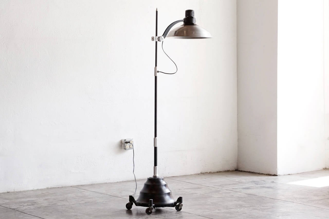 Industrial era sunlamp by General Electric, New York. We refinished this unusual piece in black and silver and converted it for use as a floor lamp. All original hardware, polished. Rolls on casters. Excellent steampunk/ industrial