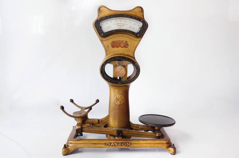 Wonderful candy store weight scale by The Dayton Ohio Scale Co., circa 1920s. Composed of cast iron with gold paint overlay. Lovely antique patina with original label and hardware throughout. New glass. In working condition. This piece is a gem.