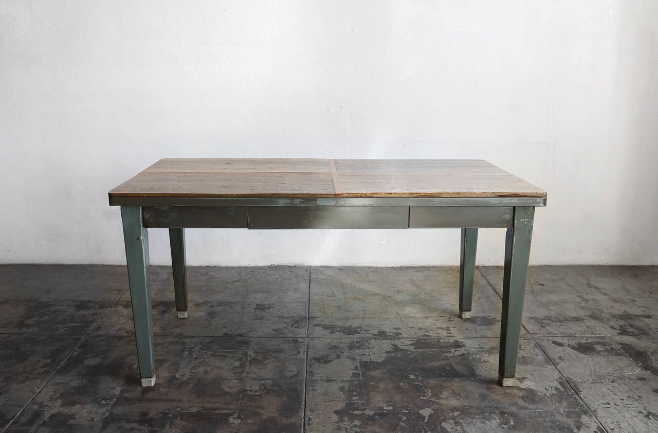 Classic American steel tanker table with tapered legs and single drawer. Original Formica table-top has been replaced with reclaimed wood. Wonderful vintage patina.