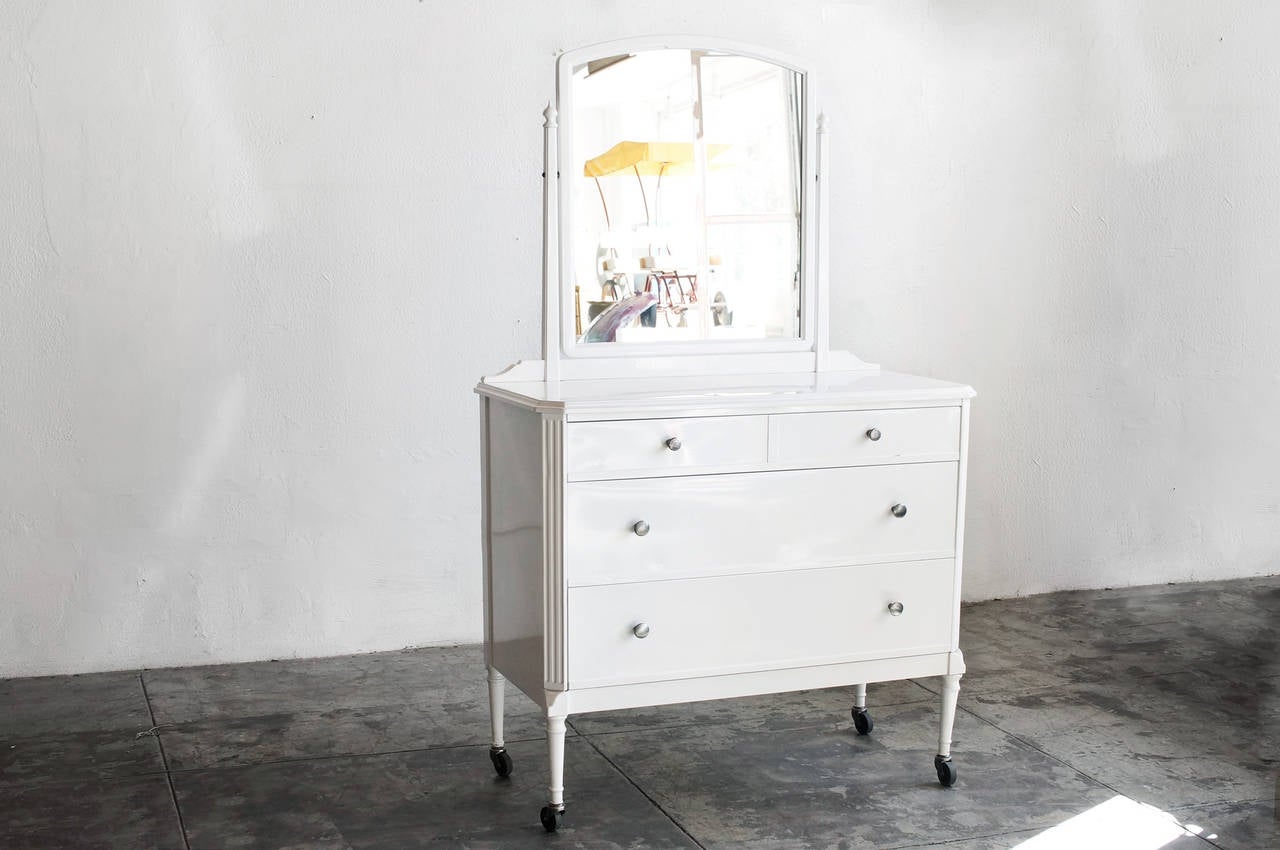 1920s steel vanity by Doehler Metal Furniture Co., featuring 3 drawers, beveled corners and detailed hardware. Rolls on casters. Newly refinished in high-gloss white powder coat. 

Dimensions: 19.5