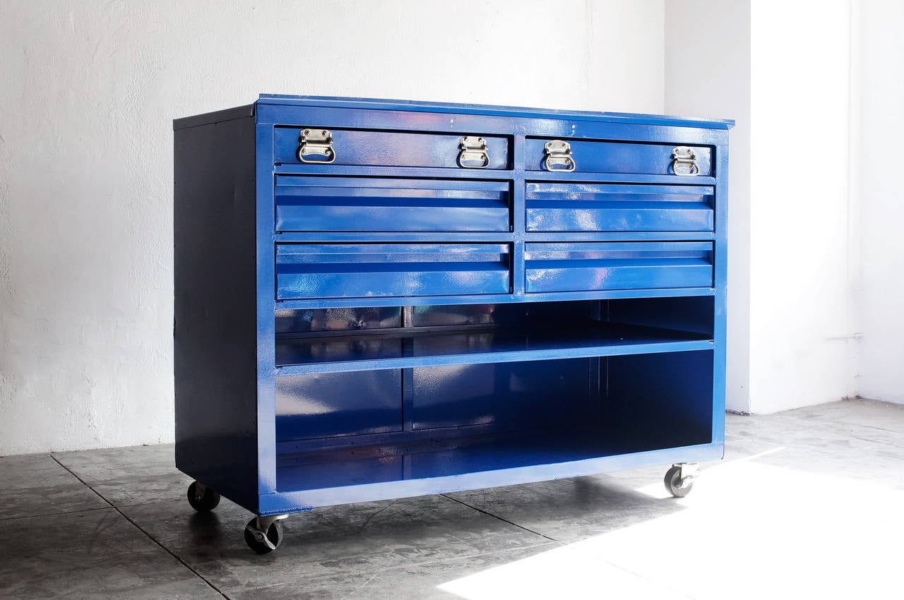 Vintage construction-site tool cabinet featuring heavy-duty hardware and locking casters. Six drawers and open shelving. Newly refinished in a royal blue powder coat. 

Dimensions: 26.25