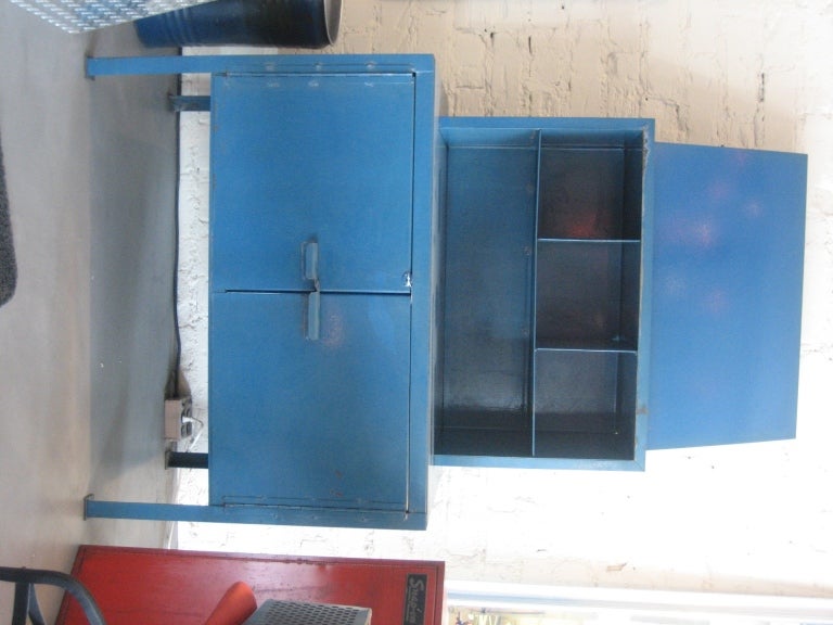 A unique industrial work station in fabulous blue paint. The top piece was likely intended to display sample or assembly drawings. This piece would transition well into the home as a dining room sideboard, dry bar, or office and art room storage