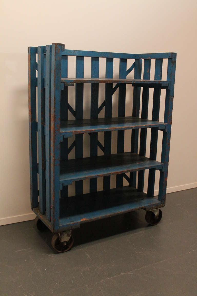 Fantastic and very durable distressed blue painted oak factory rolling shelving.
The original orange paint can be seen under the blue  , mostly on the back metal strapping.