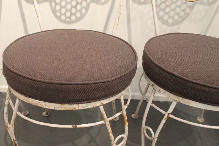 Very strong graphic perforated iron draped backrest design in these 1940's French garden chairs.
New cushions upholstered in a charcoal linen.
The iron is distressed and shows desirable wear and patina.
They can be sandblasted and powder coated