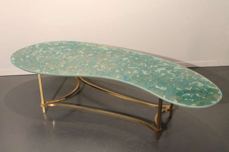 Wonderful amoeba shaped cocktail table with acrylic mosaic top . The table top surface has a water like effect with bubbles.
Brass base.