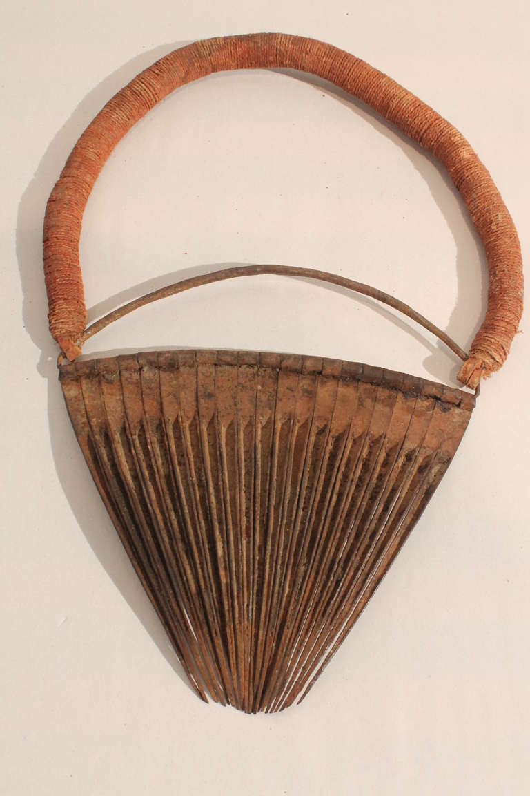 Great graphic sculptural quality to this hand made iron loin cover which covered the female genitalia.
The natural dyed string section was worn around the waist like a belt.