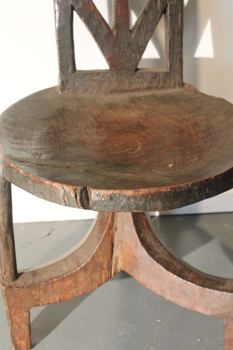 Great sculptural Ethiopian chair with native repair to seat and 3 bullets added as decoration.