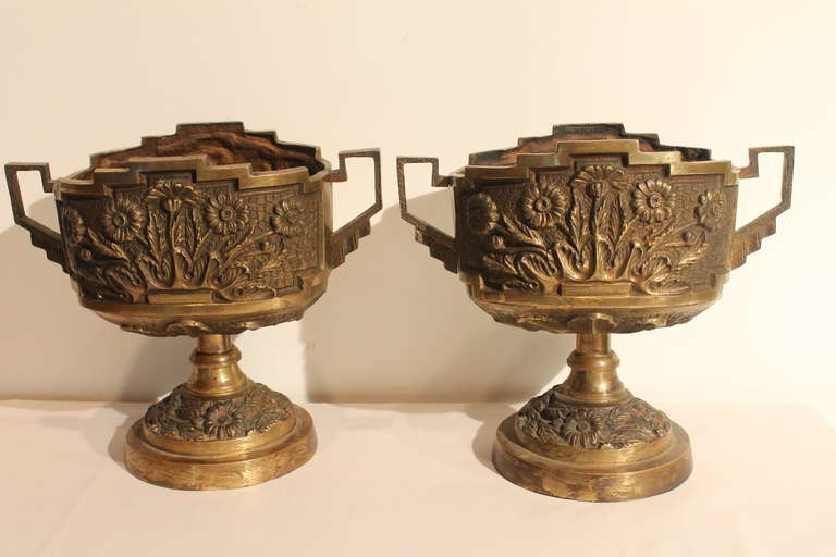 Great graphic line and crisp detailed casting in this pair of Art Deco bronze floral detailed urns.