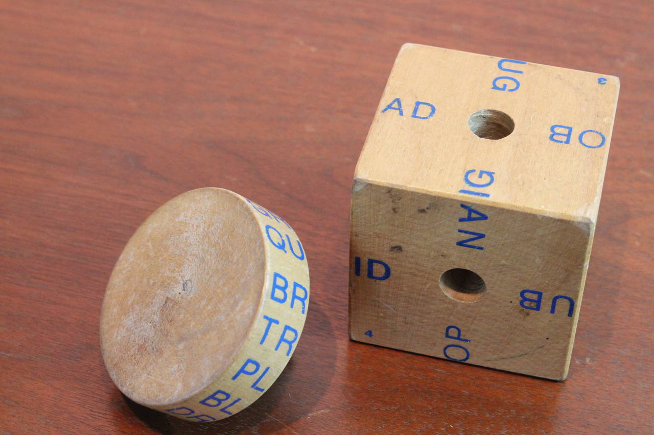 Ingenious childs toy spelling cube with a removable spinning dial that can be placed in the center of any of the sides of the cube to form different words.