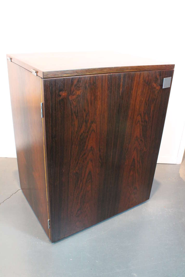 A beautiful example of a Mid-Century Modern folding bar cabinet in rosewood.Manufactured by Dyrlund, Denmark. Erik Buck (attributed) designed this rosewood cabinet to open into a bar with plenty of room for glasses, bottles, and shakers mounted on