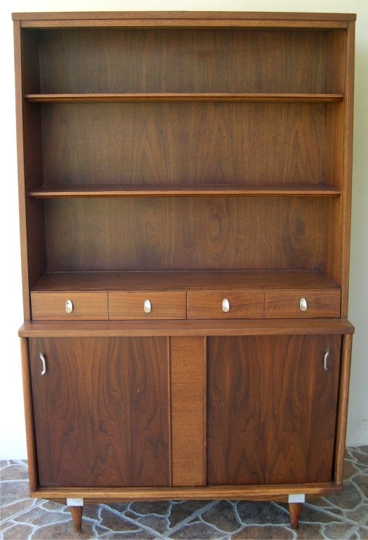 Mid- Century Modern Walnut Bookcase Paul Mc Cobb with 4 shelves, 4 small drawers and two lower  sliding doors.