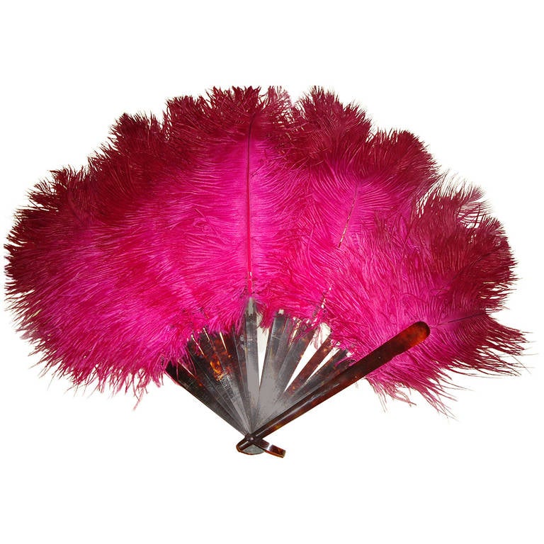 Antique fuchsia pink ostrich fan with a conch seashell arrangement.