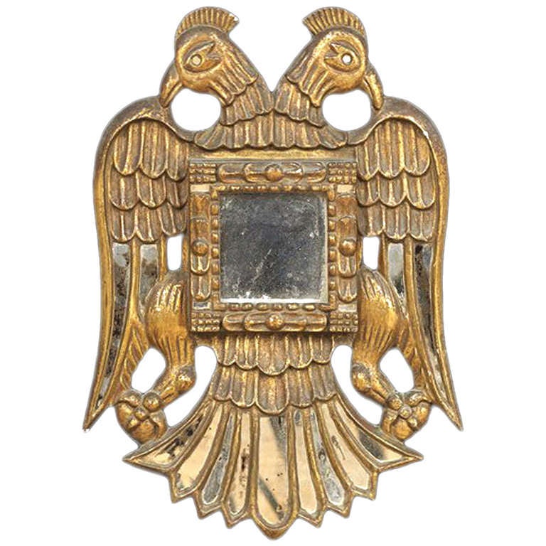 Miroir colonial espagnol ancien dans un cadre en bois sculpté et doré. Du Pérou, probablement de la région de Cusco, vers le 19e siècle. Le cadre inhabituel représente un aigle bicéphale très stylisé, aux ailes et à la queue symétriquement