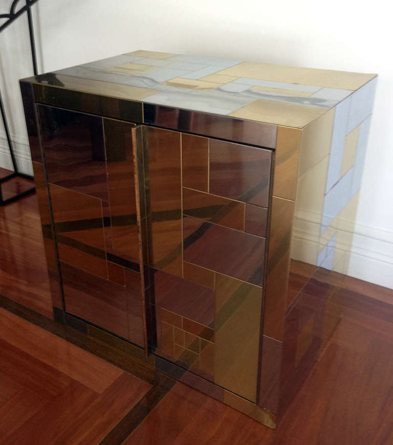 A chrome and brass veneered cityscape cabinet by Paul Evans for Directional circa 1970s. The cabinet features two doors that open to a shelf. The interior, like the exterior was clad in the meta veneer. The cabinet has an angled wall-hanging