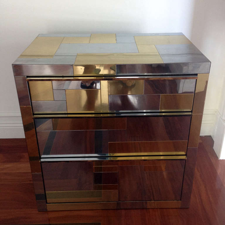 A chrome and brass veneered cityscape cabinet or low chest of drawers by Paul Evans for Directional circa 1970s. The cabinet features three drawers with wood pulls. The cabinet has an angled wall hanging mechanism on the back, but it was used as a