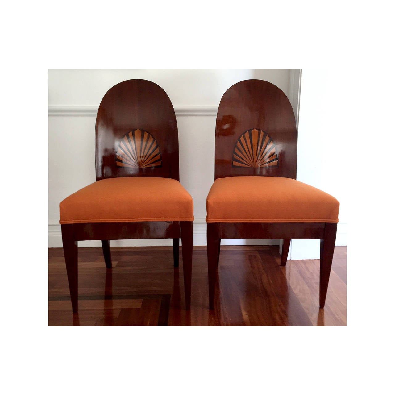 A striking pair of antique Biedermeier chairs made of mahogany circa 1820s', likely from Vienna, Austria. The chairs features a domed and curved back, creating a historical yet simple architectural form that fits seamlessly in modern interior. The