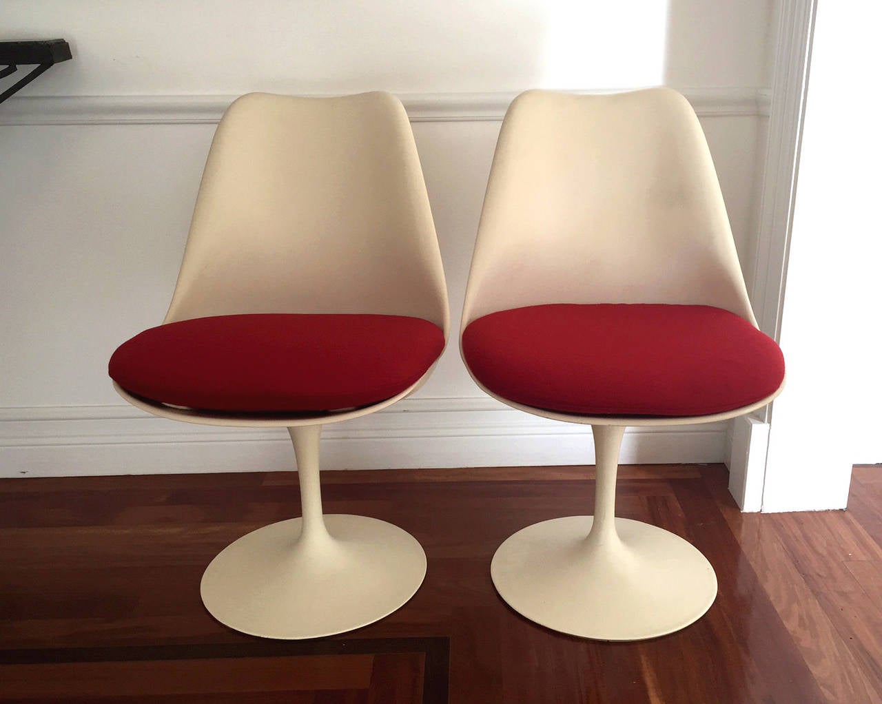 A pair of iconic tulip swivel chairs designed by Eero Saarinen for Knoll. These chairs are authentic Knoll production dated 1972. New red wool cushions custom made. Retains Knoll stickers.