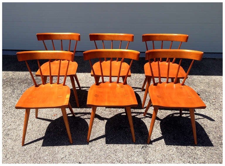 A set of six dining chairs with curved back support and visible dowel joints of the spindled legs. Designed by Paul McCobb for Planner Groups. An iconic mid-century design with a shaker sensitivity. One still retains the original foil decal. En