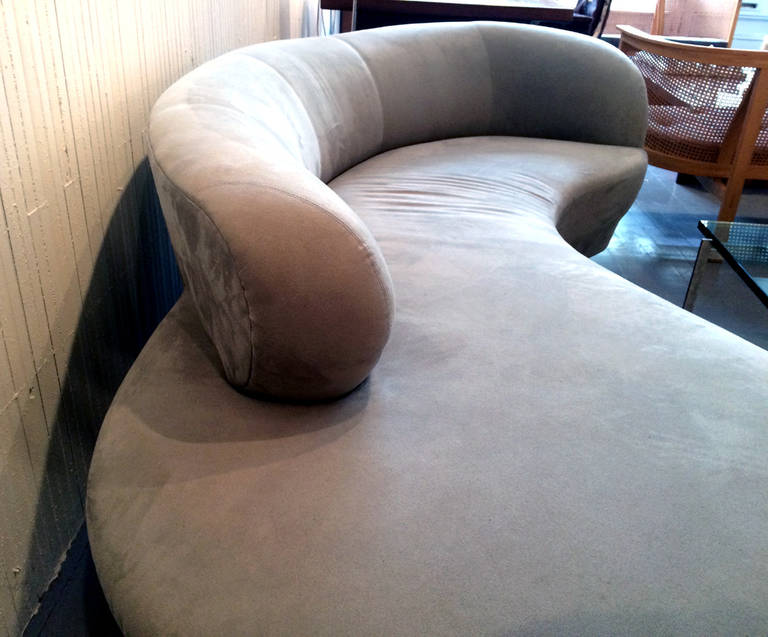 A large serpentine sofa designed by Vladimir Kagan for Directional, circa 1970s. The free-form sofa features a partial back rest supported by two upholstered pedestal feet and a medium Lucite plank. The pale blue microfiber fabric is of good