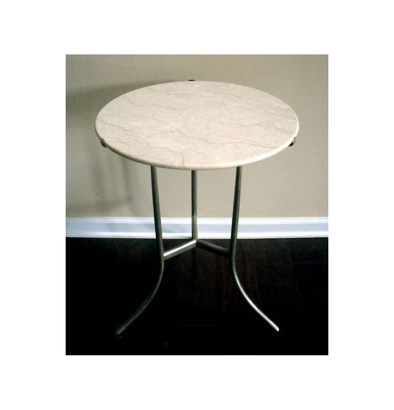 Elegance and Grace denotes the design by Cedric Hartman (b 1929). This iconic side table is an interpretation of classic gueridon and it has a cast bronze base with a white wash finish and a marble round top. Inscribed as Cedric Hartman.