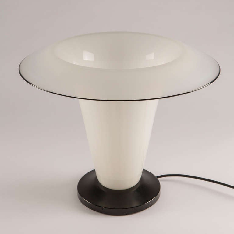 Marvellous Murano glass table lamp.
Metal black lacquered base and a huge flower shaped milky glass shade with a black rim.