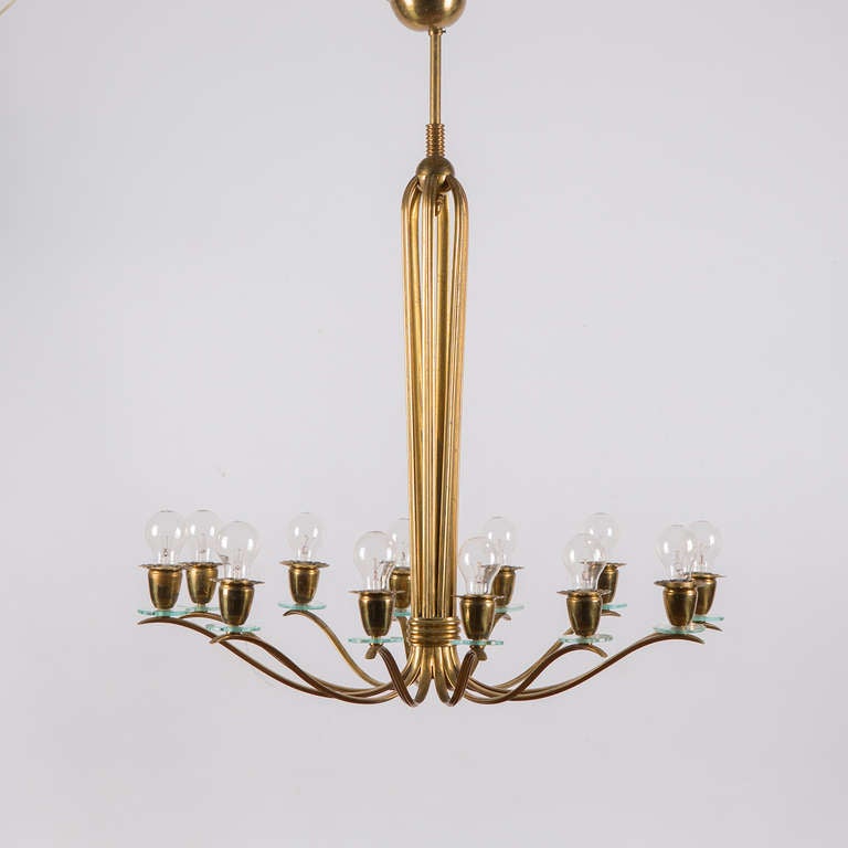 Beautiful brass chandelier attributed to Pietro Chiesa for Fontana Arte.
Each single brass arm blooms on the top and falls down to be joined with brass rings to the other arms. The chandelier then opens widely to reach the final elliptical shape.