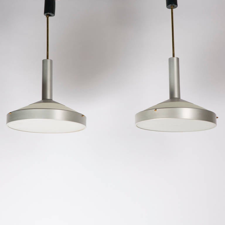 Rare set of two pendant lamps by Stilux.
Frosted glass shades with bottom and top lighting diffusion, aluminum frame and brass details.