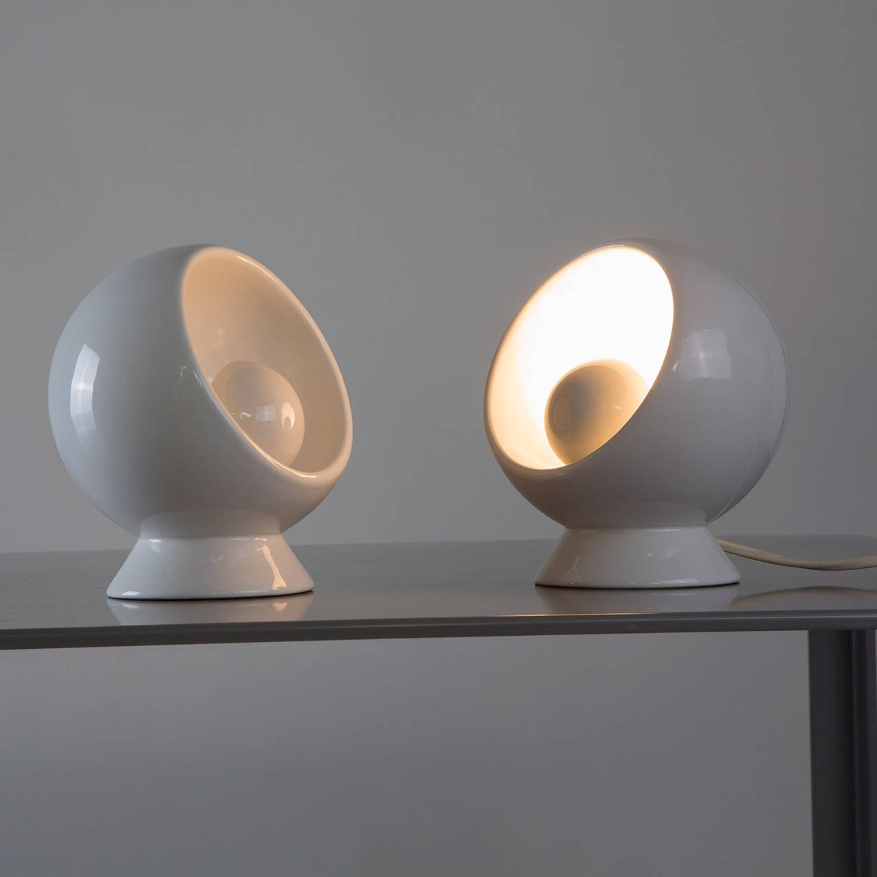 Beautiful pair of ceramic table lamps attributed to Marcello Cuneo for Gabbianelli.
Typical experimental Italian production of the period with revolving shader, curious homage to the more famous 