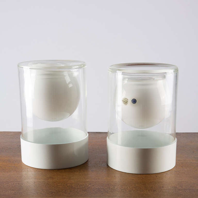 Unusual set of two Murano vases by Ugo la Pietra for la Murrina.
The pieces are composed by a thick milky/crystal glass body and a lacquered metal base.
So there's a multiple use for the vases, with or without the metal part and upside-down.
The