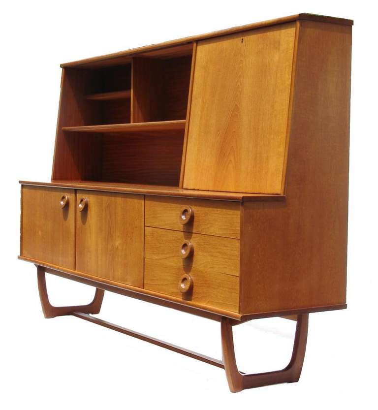 A gorgeous Danish Modern style buffet credenza. It can be used as a bar or server and a credenza with bookcase. It has a key for the pulldown. It has 2 slides glass doors. It measures approx.  50 1/4