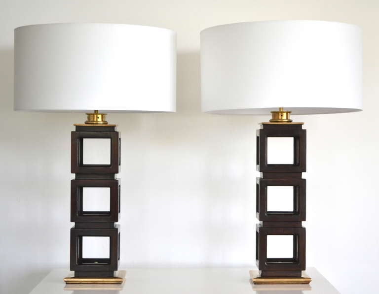 Pair of black mahogany stacked cube table lamps, c. 1940s - 1950s, by Edwin Cole. These striking examples of Mid-Century Modern design are geometric in form with open wooden cubes mounted on patinated brass bases. Both architectural and glamorous,