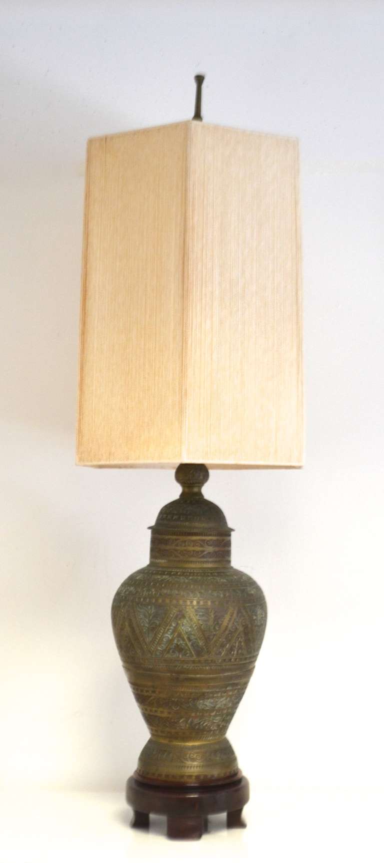 Monumental bronze table lamp in the manner of James Mont, c. 1940s -1950s. This exquisite and highly decorative lamp with Ottoman Empire style detailing is mounted on a footed mahogany base.  
Measurements:
Form 34