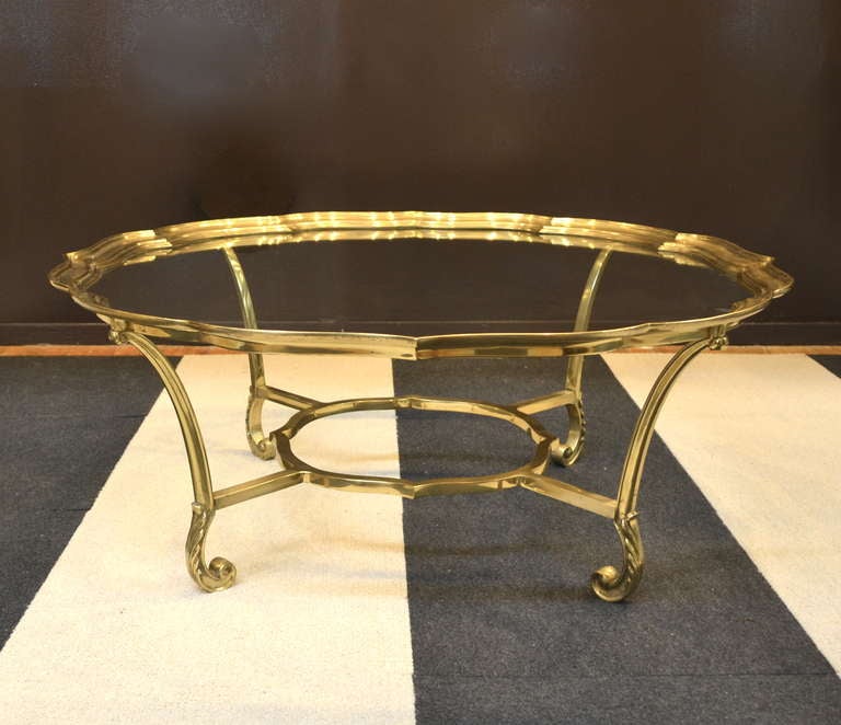Elegant brass and glass cocktail table by La Barge. c. 1970s. This  glamorous coffee table is made of hand cast solid brass with a scallop framed inset glass top. 
Please view our collection and our new showrooms in South Beach and New York
