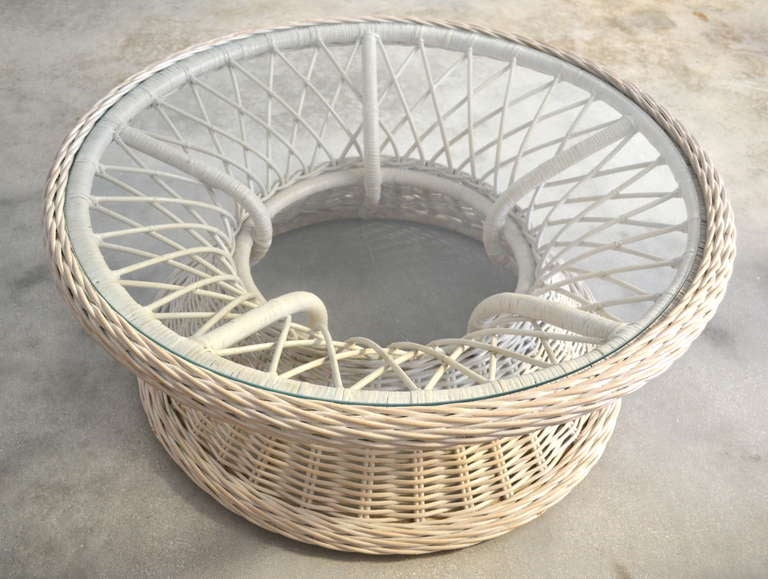 Sculptural white woven reed coffee table, c.1950s. This graphic rattan table with center spoke design and inset glass top has been masterfully considered form every angle.