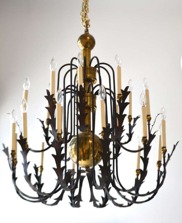 Exquisite Hollywood Regency style, twenty-arm chandelier, circa 1960-1970. This stunning brass and wrought iron chandelier is designed with scrolling arms and adorned with blackened metal acanthus leaf decoration.
Measurements:
Chandelier: 40