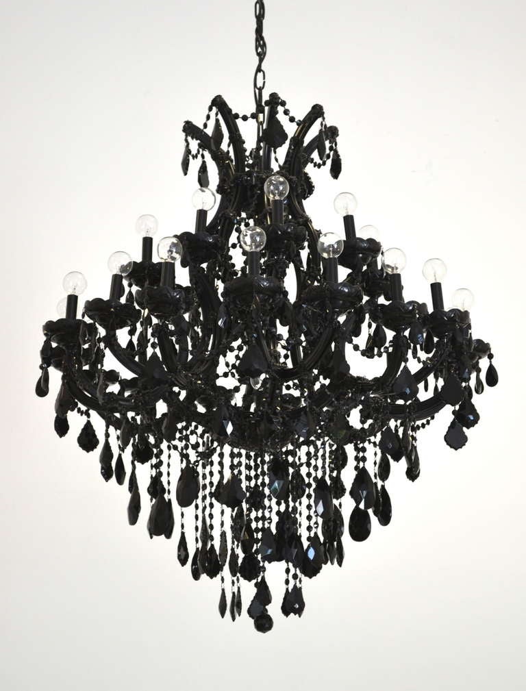 Striking custom made Maria Theresa style 25-light black glass chandelier. This dramatic chandelier is densely composed of numerous cascading glass beaded festoons, crystal drops and bobeches. The form of the chandelier is 42
