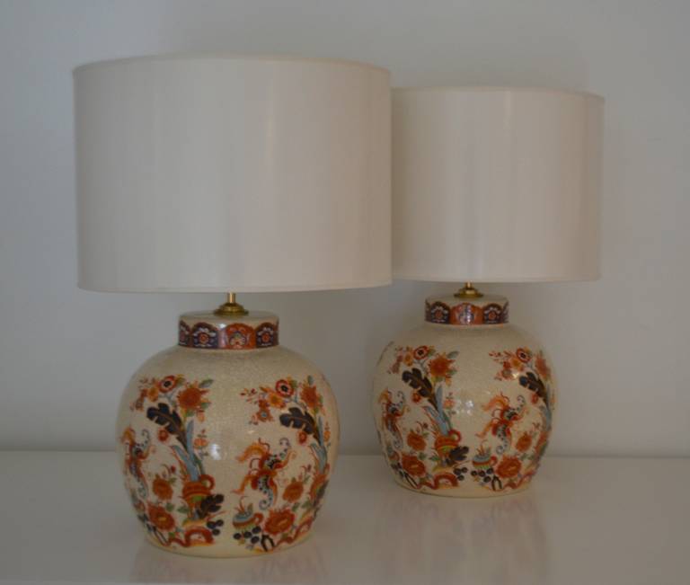 Stunning pair of Hollywood Regency Asian inspired ceramic crackle glazed  table lamps, circa 1960s. These highly decorative and intricately glazed ginger jar form lamps have been rewired with brass fittings. The height can be adjusted by adding a